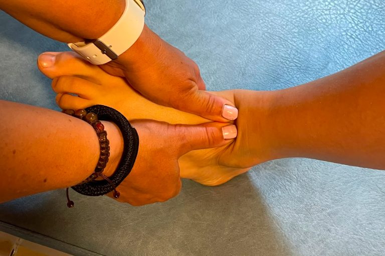 Kuvassa fysioterapeutti käsittelee asiakkaan jalkaa